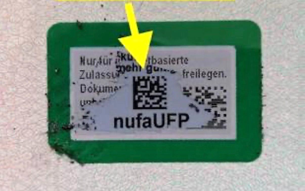 Freigelegte Fläche im Fahrzeugschein mit siebenstelligem Sicherheitscode unter dem DataMatrix-Code